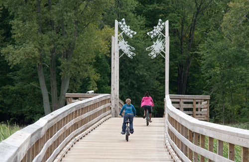 Photo: Two girls riding the "dragonfly bridge" on the Lake-to-Lake Trail. Photo by James Guilford.