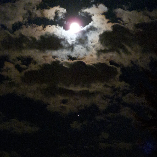 Photo: The Moon and Jupiter shine through holes in the clouds. Photo by James Guilford