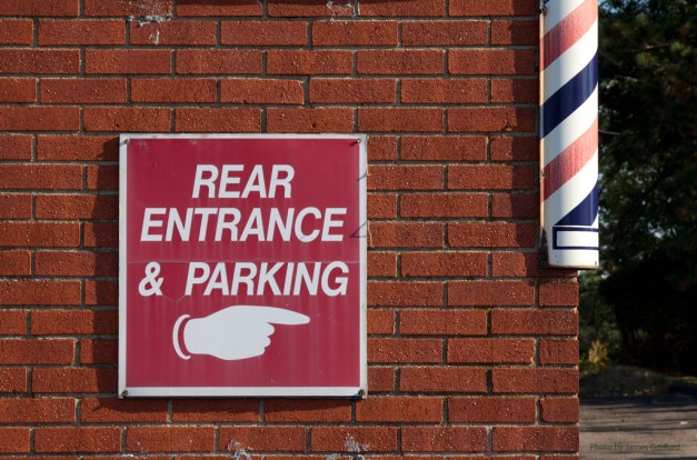 rear-entrance_9958a Photo: Signs point the way to barber shop. Photo by James Guilford.