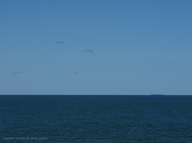 Photo: Lake Erie ore carrier boat on the distant horizon. Photo by James Guilford.