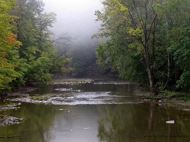 Photo: Still river waters with foggy background. Photo by James Guilford.
