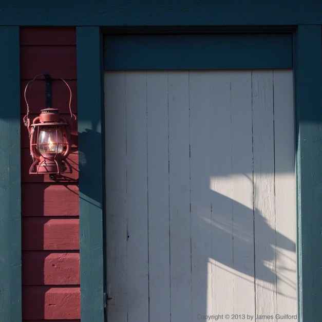 Photo: An antique lantern hangs next to a door. Photo by James Guilford.