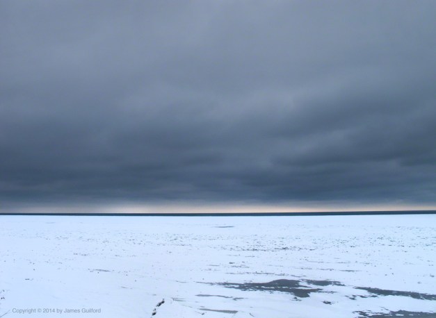 Photo: Glowering clouds over icy Lake Erie. Photo by James Guilford.