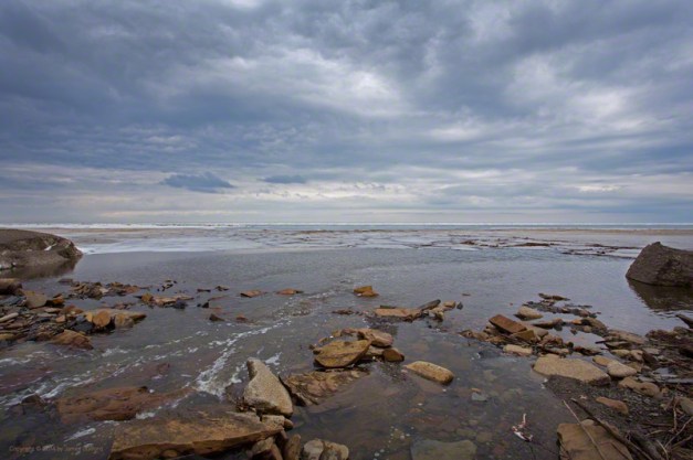 Photo: Dramatic sky over waters flowing to a still-icy Lake Erie. Photo by James Guilford.