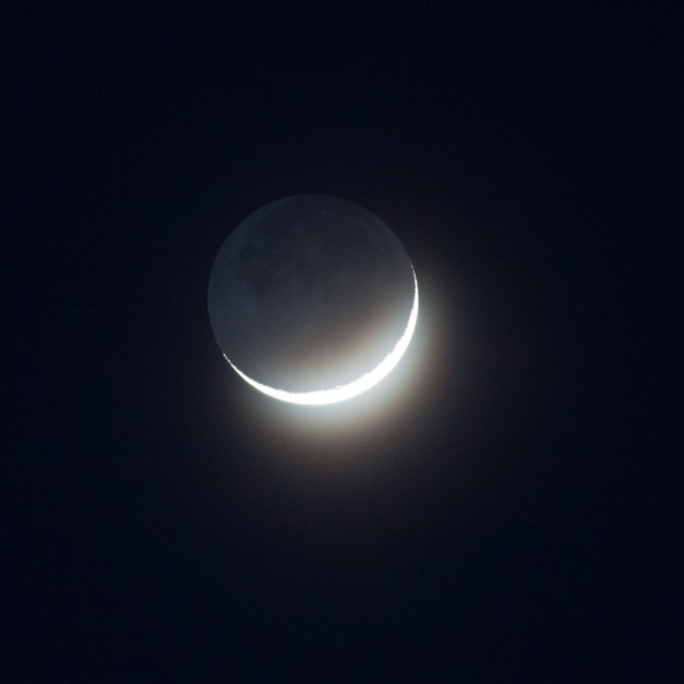 Photo: Crescent Moon through Thin Clouds. Photo by James Guilford.