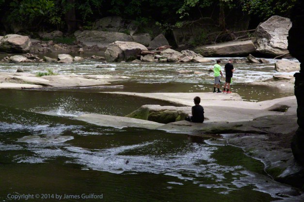 Photo: Two friends fishing while younger boy sits by himself. Photo by James Guilford.