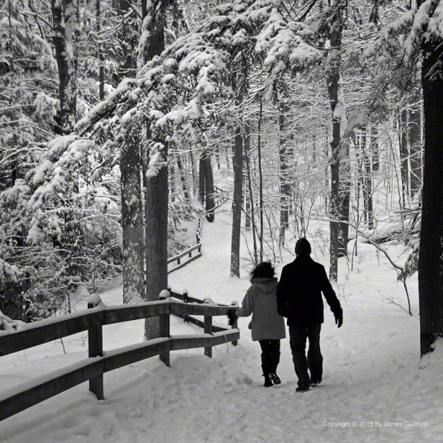 Photo: Couple walking on path in snow-filled landscape. Photo by James Guilford.