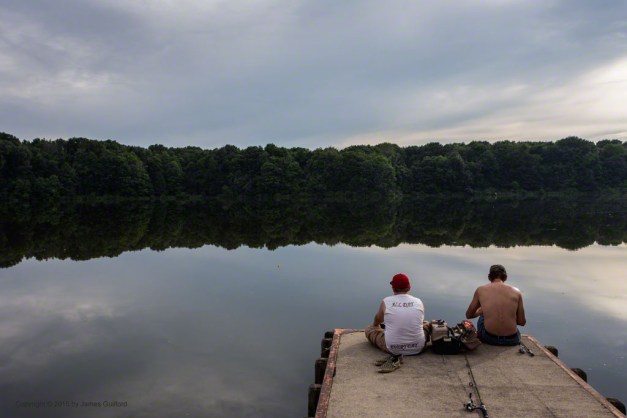 Photo: Father and son fishing on quiet lake in the evening. Photo by James Guilford.
