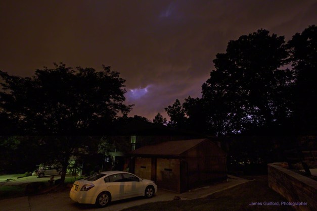 Photo: Nighttime thunderstorm over a house and trees. Photo by James Guilford.