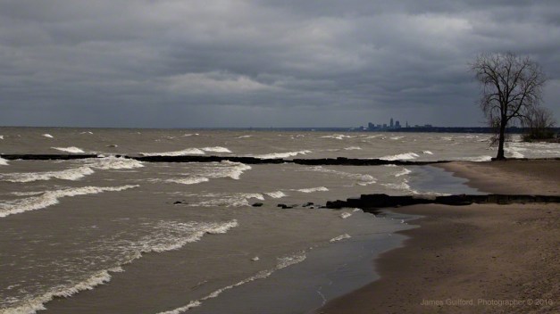 Photo: Wind-driven waves on the Lake Erie Shoreline, city of Cleveland in the background. Photo by James Guilford.