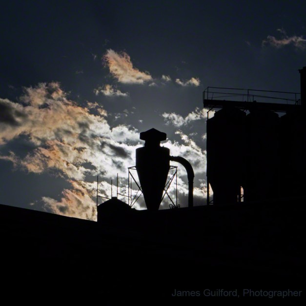 PHoto: Industrial cyclone seen with sun behind. Photo by James Guilford.