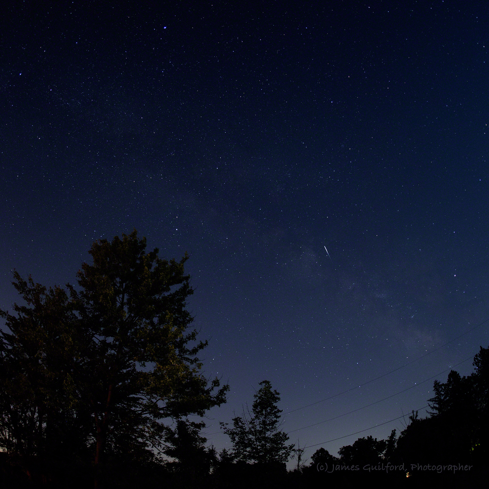 Photo: The streak of a small meteor with the Milky Way as background. Photo by James Guilford.