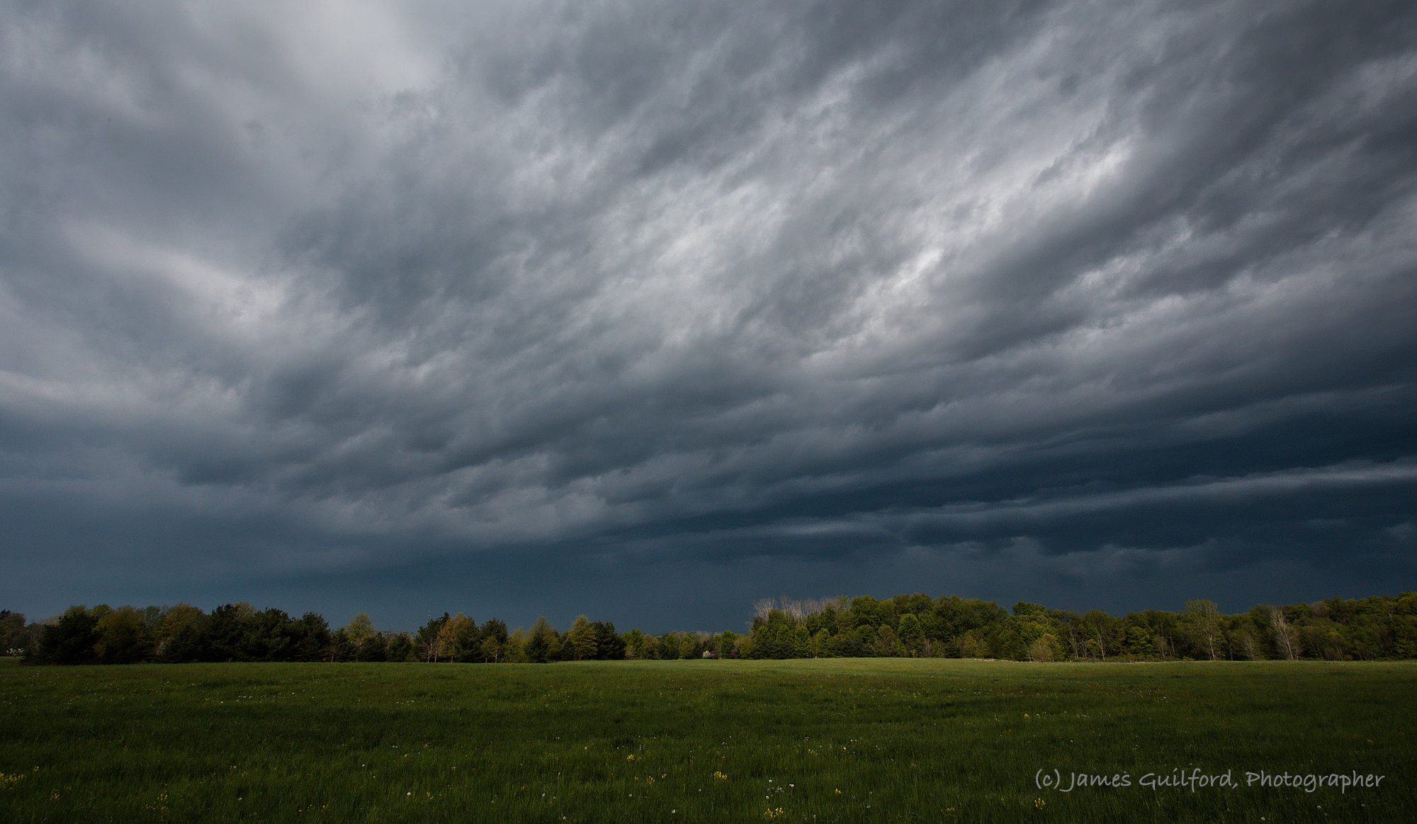 Photo: A spot of sun appeared on the green field just before the storm swept in and blotted it out. Photo by James Guilford.