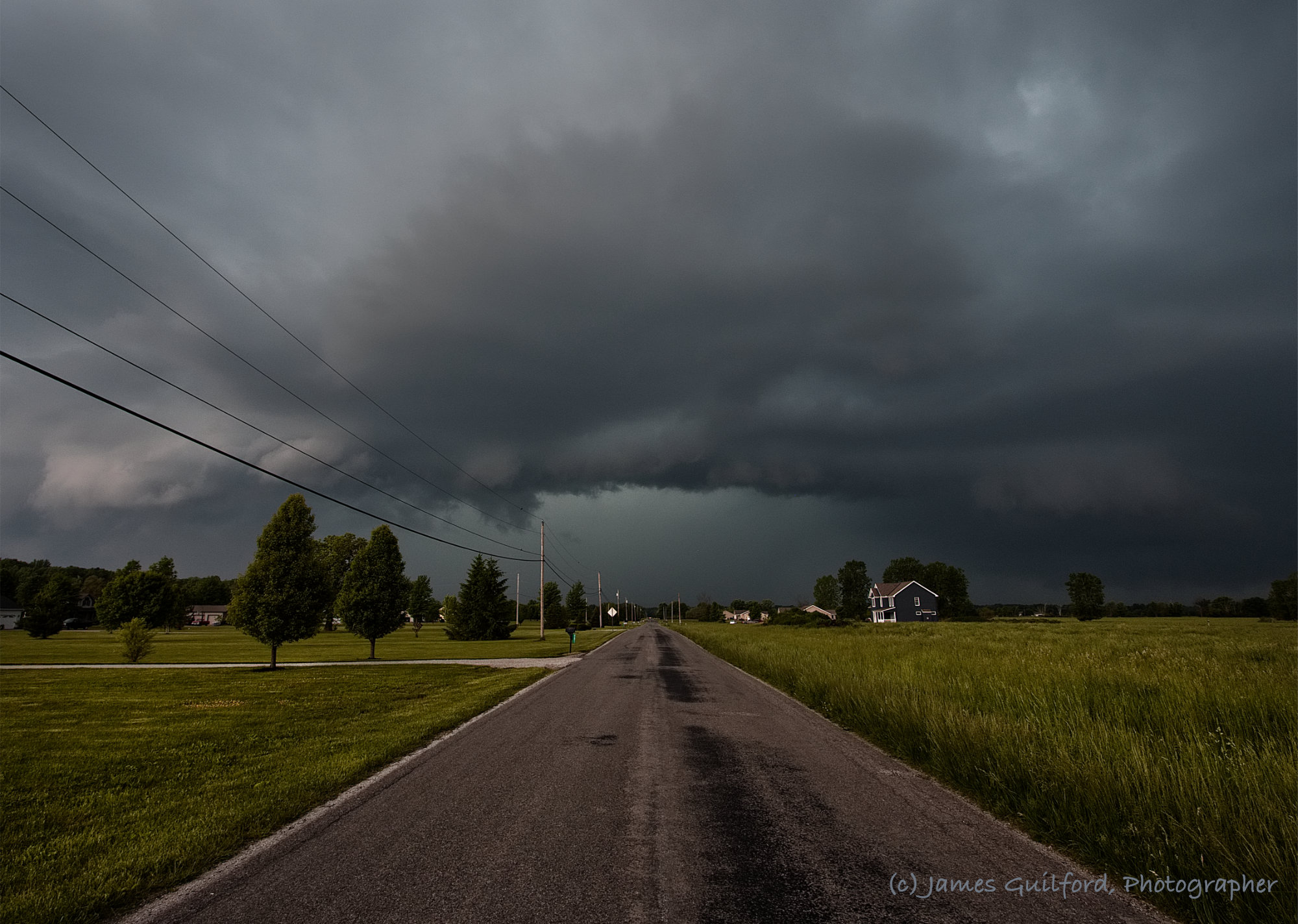 Photo: Storm clouds over a country road. Photo by James Guilford.