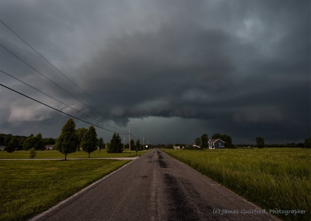 Photo: Storm clouds over a country road. Photo by James Guilford.