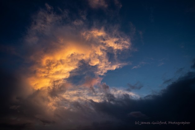 Photo: Fiery Wave. A swirl of storm clouds lit by sunset. Photo by James Guilford.