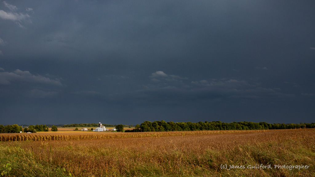 Photo: A severe thunderstorm passes to the south of a farm in rural Wayne County, Ohio as bright sunshine illuminates barn and field. Photo by James Guilford.