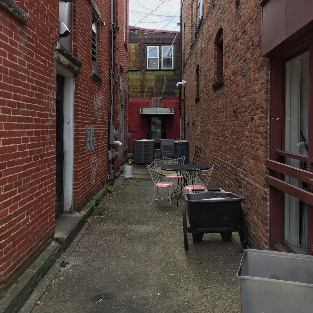 Photo: Grungy alleyway with patio seating. Photo by James Guilford.